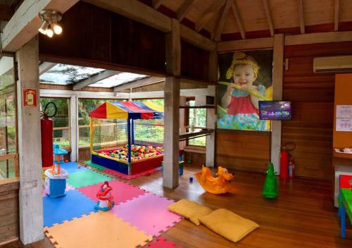 uma sala de jogos com um equipamento de brincar para crianças numa casa em Vila Ventura Ecoresort em Viamão