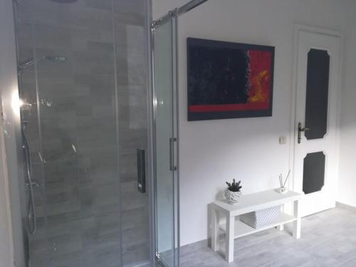 een badkamer met een douche en een tafel en een schilderij bij Villa Giuliana in Cannobio