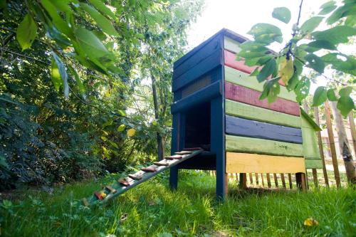 a colorful out house sitting in the grass at De kiezel in Hasselt