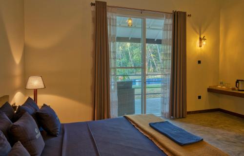 a bedroom with a bed and a large window at Athena Lake in Dambulla