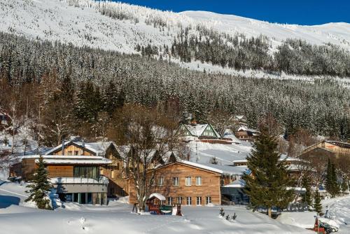 a town in the snow with a mountain in the background at Hotel Olympie in Špindlerův Mlýn