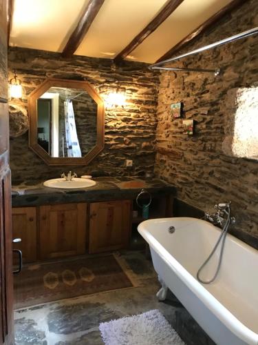 a stone bathroom with a tub and a sink at Quinta do Vale Coelheiro in Toulões
