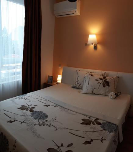 a bedroom with a bed with a floral bedspread and a window at Hotel39 in Plovdiv