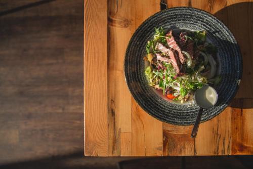 a bowl of food on a wooden table at Novotel Cardiff Centre in Cardiff