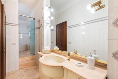 La salle de bains est pourvue d'un lavabo et d'un miroir. dans l'établissement Design Apartments Florence- Florence City Center, à Florence