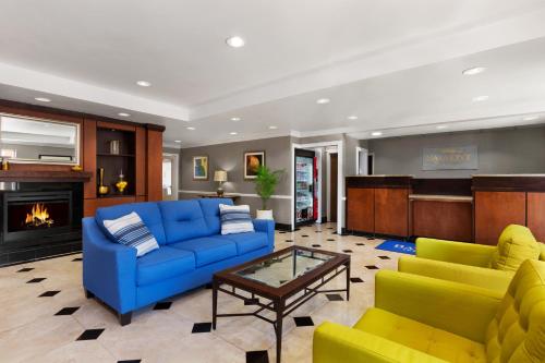 a living room with a blue couch and yellow chairs at Baymont by Wyndham Lithia Springs Atlanta in Lithia Springs