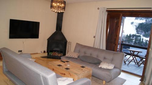 a living room with a couch and a fireplace at Soldeu Paradis Tarter Mig in El Tarter