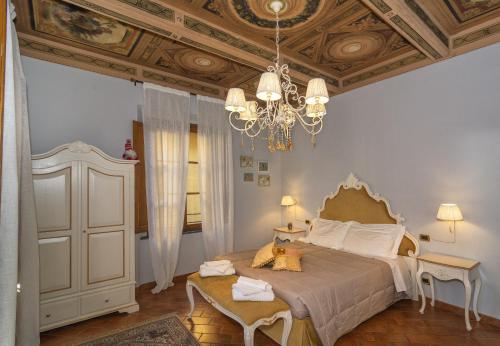 a bedroom with a bed, chair, lamp and a table at Rinascimento Bed & Breakfast in Pisa
