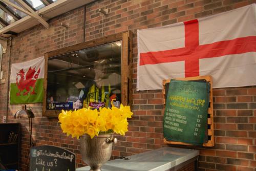 a flag and a vase with yellow flowers on a wall at Novotel Cardiff Centre in Cardiff