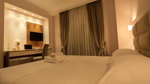 a hotel room with a large bed and a desk at Royal Hill Hotel in Tirana
