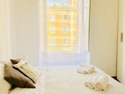a bedroom with two towels on a bed with a window at Le Rondini a Roma in Rome