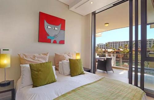 a bedroom with a bed with a cat painting on the wall at Waterfront Stays in Cape Town