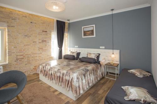 a bedroom with a bed and a brick wall at Aspalathos Residence in Split
