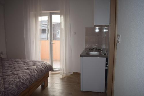 Un baño con una cama y un lavabo en una habitación. en Apartments Nediljko & Mila, en Zadar