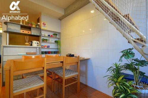 a room with a table and chairs and a staircase at Alphabed TakamatsuKawaramachi 501 / Vacation STAY 21604 in Takamatsu
