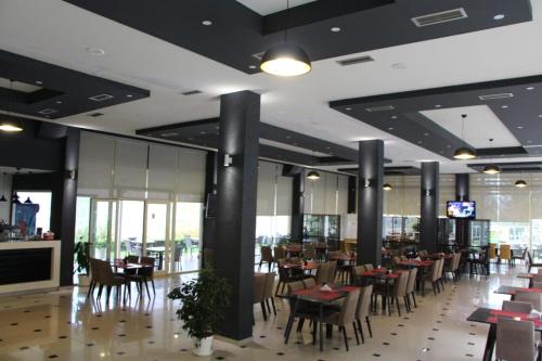 a dining room with tables and chairs in a restaurant at Hotel Auto Grill Roberti in Tepelenë