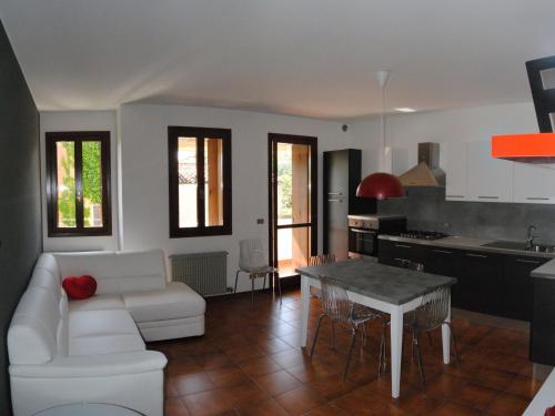 a living room with a white couch and a table at Appartamenti Vacanza Tra Venezia e le Dolomiti in Vittorio Veneto