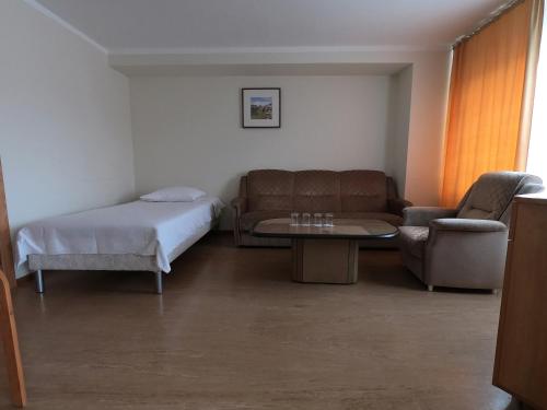 a room with a bed and a couch and a table at Hotel Madona in Madona