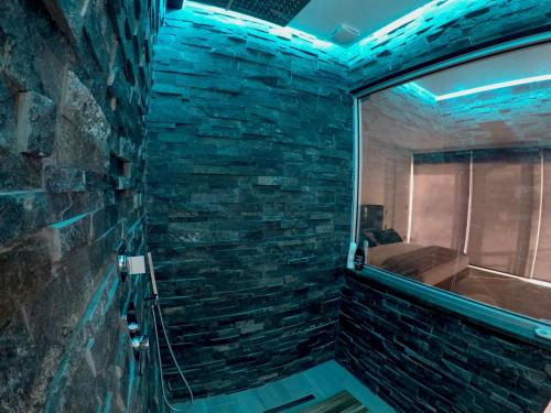 a bathroom with a tub and a stone wall at Rokamare Beach Resort in Liapades