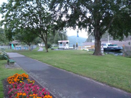 a park with flowers and a sidewalk next to a river at Hotel Garni Reis in Treis-Karden