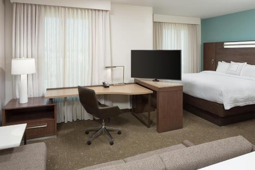 a hotel room with a bed and a desk with a computer at Residence Inn by Marriott Ontario Rancho Cucamonga in Rancho Cucamonga