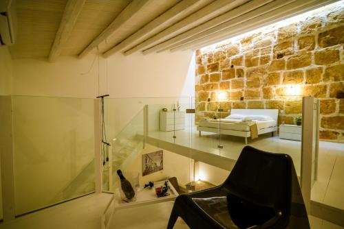 a room with a bed and a chair in a building at LA CARRETTERIA, ospitalità siciliana in Avola