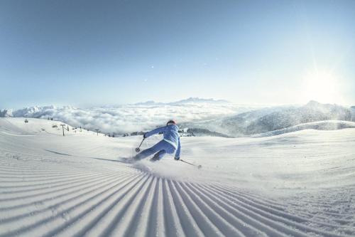 a person is skiing down a snow covered slope at Grafenberg Chalet in Wagrain