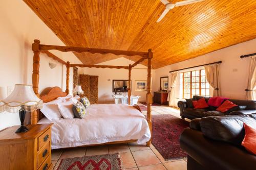 1 dormitorio con cama y techo de madera en Olive Tree Farm, en Magaliesburg