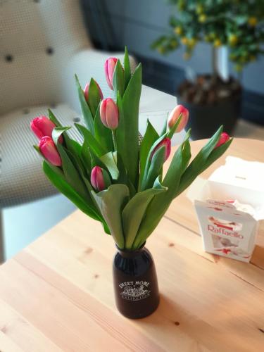 a vase filled with pink tulips on a table at Orange Tree Hotel in Będzin
