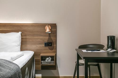 a hotel room with a bed and a desk and a chair at Best Western Hotel Savoy in Karlstad