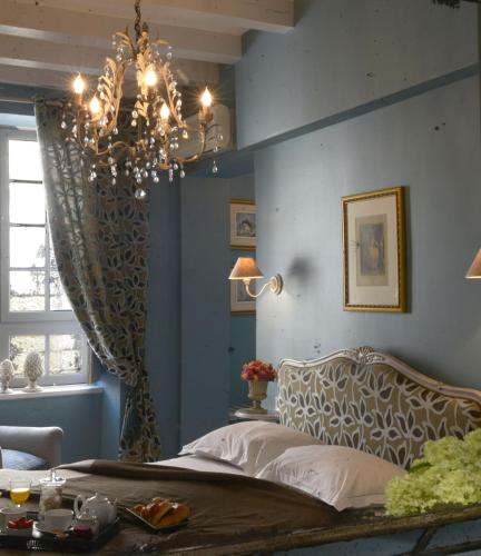 a bedroom with a bed and a chandelier at Hôtel Saint Pierre Boutique-Hôtel in Saumur