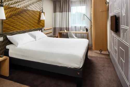 a hotel room with a bed and a desk at ibis Glasgow City Centre – Sauchiehall St in Glasgow