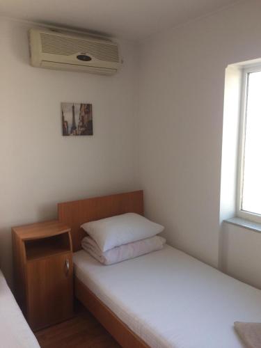 a small bedroom with two beds and a window at Pensiunea Everest in Craiova