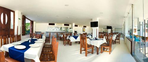 un comedor con mesas y sillas en un restaurante en Hotel Majams Resort, en San Gil
