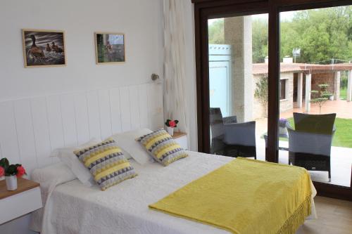 um quarto com uma cama com um cobertor amarelo em Apartamentos As Lagoas em O Grove