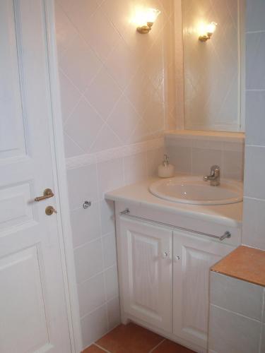 a white bathroom with a sink and a mirror at Patmos Houses in Patmos