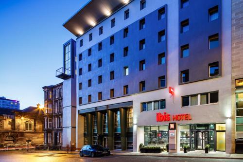 a building with a car parked in front of it at ibis Glasgow City Centre – Sauchiehall St in Glasgow