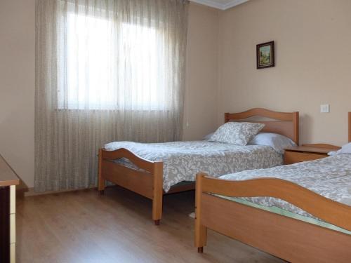 um quarto de hotel com duas camas e uma janela em BARRIO DE ABAJO 50 2º em Felechosa