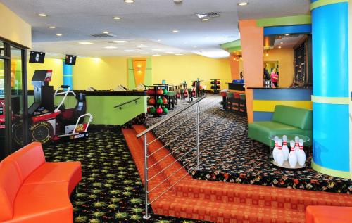 a room with a gym with orange chairs and bowling lanes at Coral Beach Resort in Myrtle Beach