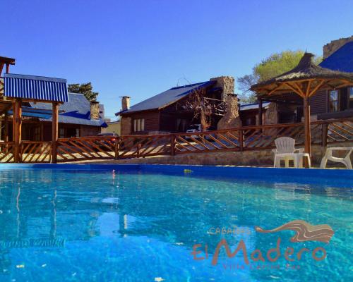 a large swimming pool in front of a house at Cabañas El Madero in Villa Carlos Paz