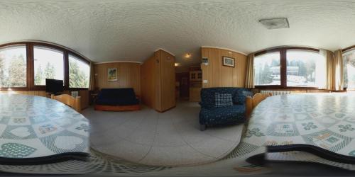a room with a table and chairs and windows at Marilleva 1400 "Il volpino" in Marilleva