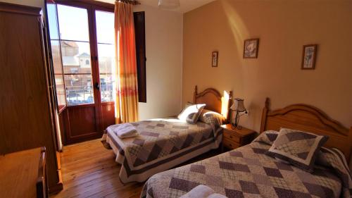 a bedroom with two beds and a window at Pensión Sandoval in León