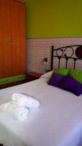 a bedroom with a bed with towels on it at Pensión Sandoval by gaiarooms in León