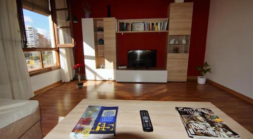 a living room with a television and a remote control at Pensión Sandoval by gaiarooms in León
