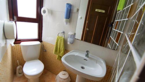 a small bathroom with a toilet and a sink at Pensión Sandoval by gaiarooms in León