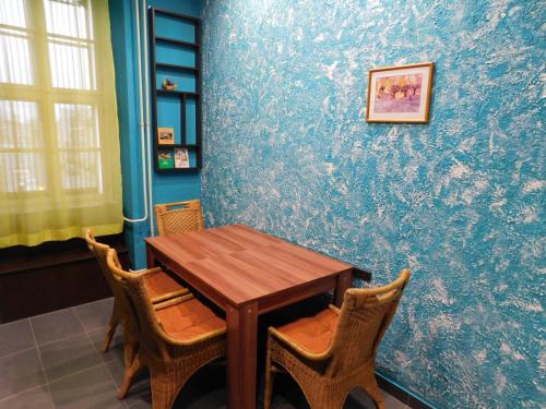 a table and chairs in a room with a blue wall at Körmend lakás in Körmend