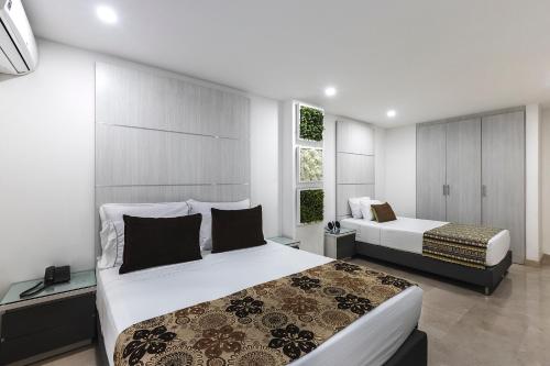 1 dormitorio con 2 camas y ventana en Hotel Madeiro, en Medellín
