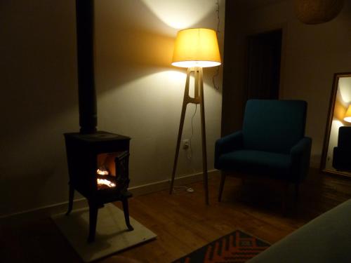 a room with a stove and a chair and a lamp at Olmedilla in Olmeda de las Fuentes