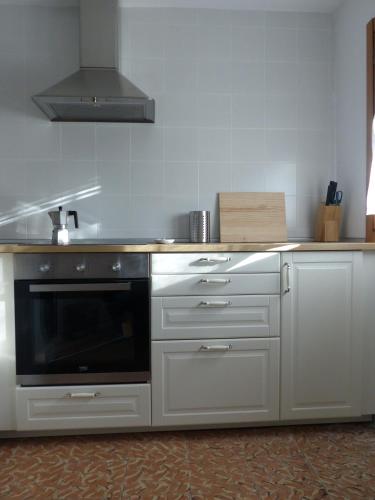 a kitchen with white cabinets and a black microwave at Olmedilla in Olmeda de las Fuentes