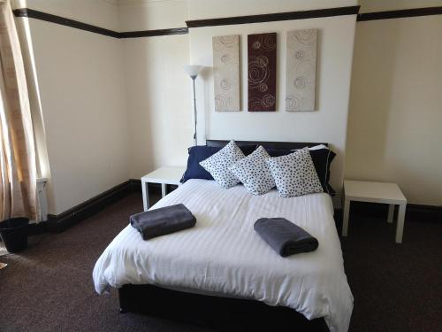 um quarto com uma cama grande com almofadas em John St Town House - Self Catering - Guesthouse Style - Great Value Family and Double Rooms em Workington